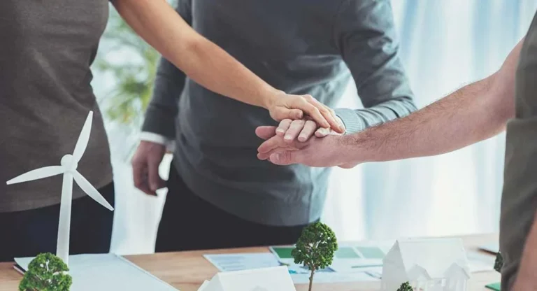 office workers hold hands together