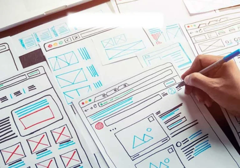 creating sketch of a website on paper with pen