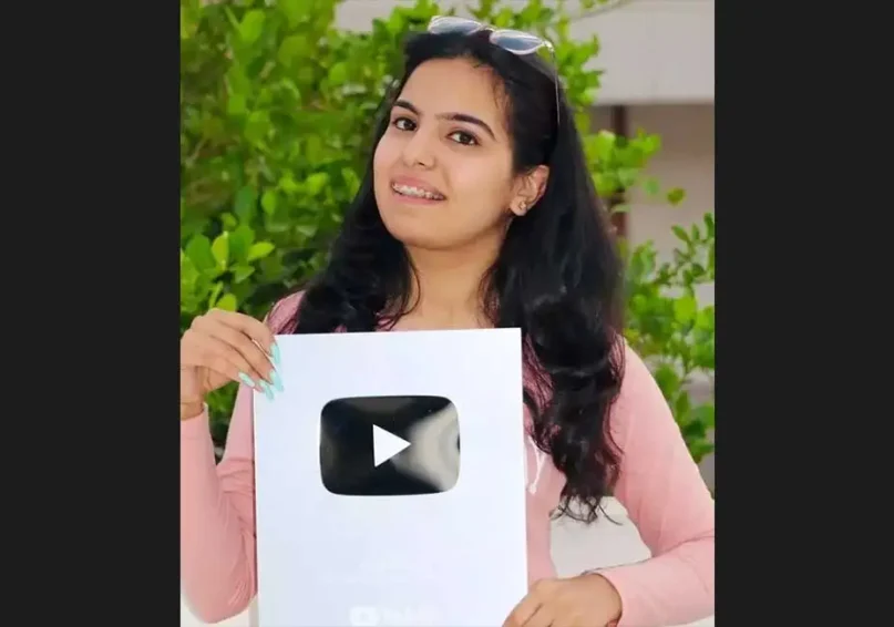 a girl holding youtube silver play button